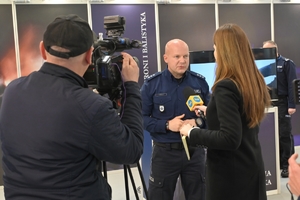 Zdjęcie przedstawia policjanta nieudzielającego wywiadu stacji telewizyjnej.