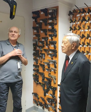 Na zdjęciu znajduje się zbiór broni, profesor Henry oraz biegły z CLKP