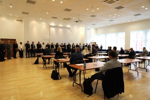 Zdjęcie przedstawia  salę,  na której prowadzony był egzamin wraz z komisją i egzaminowanymi.