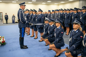 Komendant Główny Policji nadinsp. Marek Boroń mianuje policjantów na pierwszy stopień oficerski przykładając im szable do ramienia