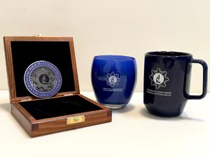 Kubek, świeczka oraz coin z logo Centralnego Laboratorium Kryminalistycznego Policji-rzeczy do wygrania w licytacji Wielkiej Orkiestrze Świątecznej Pomocy
