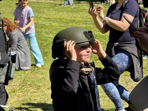 Chłopiec przymierza taktyczny kask w trakcie Pikniku Europejskiego w łazienkach Królewskich