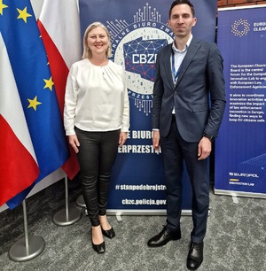 Uczestnicy konferencji stoją obok siebie podkomisarz Łukasz Kocielnik oraz Agnieszka Łukomska z Centralnego Laboratorium Kryminalistycznego Policji i pozują do zdjęcia.