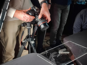Uczestnicy szkolenia szkolą się podczas warsztatu fotograficznego ze szczególnym uwzględnieniem wykonywania zdjęć w trudnych warunków atmosferycznych czy niespecyficznym podłożu. Na zdjęciu widać aparat fotograficzny i osobę która wykonuje zdjęcie.