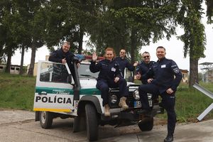 Uczestnicy warsztatów stoją jeden obok drugiego w kombinezonach kryminalistycznych i pozują do zdjęcia.