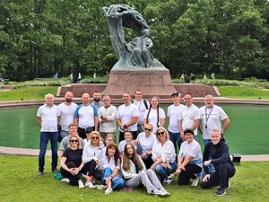 Kadra kierownicza Centralnego Laboratorium Kryminalistycznego Policji oraz funkcjonariusze i pracownicy pozują do wspólnego zdjęcia na tle pomnika Fryderyka Chopina w łazienkach Królewskich w Warszawie.