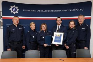 Zdjęcie przedstawia Dyrekcję Centralnego Laboratorium Kryminalistycznego Policji oraz Naczelników Wydziału Badań Genetycznych Centralnego Laboratorium Kryminalistycznego Policji w raz z Gordonem Honeyewellem. Wszyscy pozują do wspólnego zdjęcia.