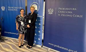 Zastępca Dyrektora Centralnego laboratorium Kryminalistycznego Policji podinsp. Anna Przewor oraz mł. insp. Edyta Kot Naczelnik Wydziału Badań Daktyloskopijnych i Traseologicznych CLKP pozują do zdjęcia na ściance Prokuratury Krajowej