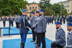 Komendant Główny Policji nadinsp. Marek Boroń gratuluje ściskając dłoń nowego oficera polskiej Policji podkom. Bartłomieja Pelca podczas promocji oficerskiej.
