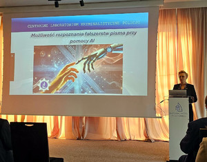 Zdjęcie przedstawia Zastępce Dyrektora Centralnego Laboratorium Kryminalistycznego Policji podinsp. Annę Przewor podczas prelekcji sympozjum poświęconego bezpieczeństwu publicznego dokumentów.