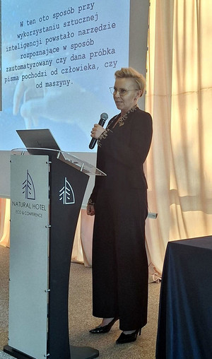 Zdjęcie przedstawia Zastępce Dyrektora Centralnego Laboratorium Kryminalistycznego Policji podinsp. Annę Przewor podczas prelekcji sympozjum poświęconego bezpieczeństwu publicznego dokumentów.