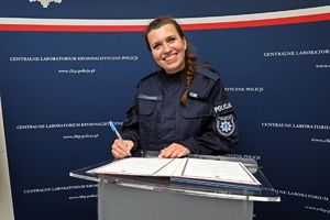 Zdjęcie przedstawia post. Pauline Samczuk, podczas składania podpisu na rozkazie personalnym.