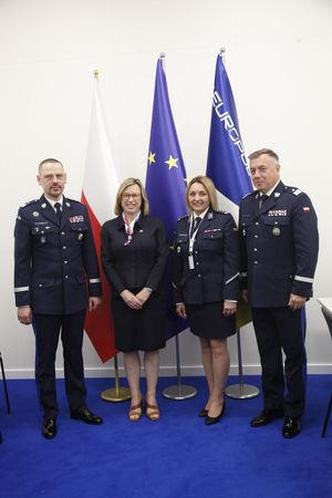 Komendant Główny Policji nadinsp. Marek Boroń,  Dyrektor Wykonawcza Europolu Catherine De Bolle, Dyrektor Centralnego Laboratorium Kryminalistycznego Policji insp. Iwony Marciniak-Krawczyk oraz nadinsp. Tomasz Michułka Zastępca Komendanta Głównego Policji pozują do wspólnego zdjęcia stojąc obok siebie.