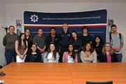 Zdjęcie przedstawia wizyty gości, studentów z amerykańskiej uczelni New Haven. Studenci pozują do zdjęcia stoją obok siebie w szeregu wraz z zastępcą Dyrektora Centralnego Laboratorium Kryminalistycznego Policji mł. insp. Kamilem Starzomczykiem.
