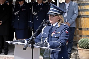 Zdjęcie przedstawia Dyrektor Centralnego Laboratorium Kryminalistycznego Policji insp. Iwinę Marciak-Krawczyk, która stoi przed mównicą i przemawia do zgromadzonych policjantów, pracowników policji oraz zaproszonych gości.