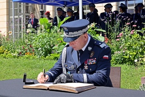 Zastępca Komendanta Głównego Policji nadinsp. dr Rafał Kochańczyk wpisuje się do księgi pamięci podczas obchodów Święta Policji Centralnego Laboratorium Kryminalistycznego Policji.