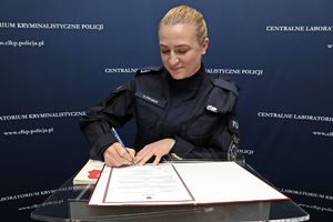 Nowo zaprzysiężona funkcjonariuszka Centralnego Laboratorium Kryminalistycznego Policji podpisuje rozkaz personalny.