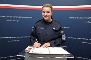 Nowo zaprzysiężona funkcjonariuszka Centralnego Laboratorium Kryminalistycznego Policji podpisuje rozkaz personalny.