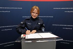 Nowo zaprzysiężona funkcjonariuszka Centralnego Laboratorium Kryminalistycznego Policji podpisuje rozkaz personalny.