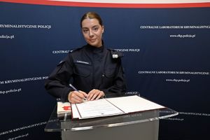 Nowo zaprzysiężona funkcjonariuszka Centralnego Laboratorium Kryminalistycznego Policji podpisuje rozkaz personalny.