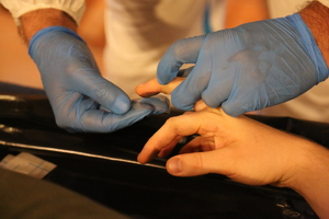 Zdjęcie technika kryminalistyki w trakcie pobierania odcisków palców