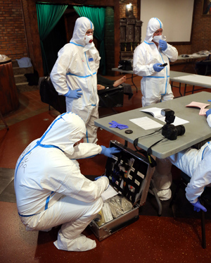 Zdjęcie techników kryminalistyki w trakcie wykonywania czynności służbowych